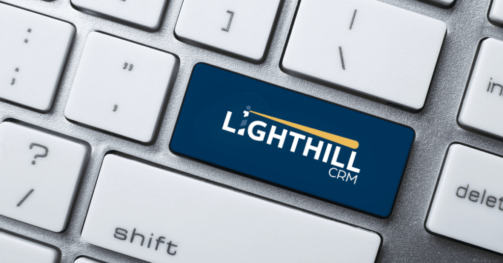Keyboard close-up featuring a blue key with the “Lighthill CRM” logo.