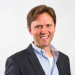 Picture of Scott Ferrebbe Founder of Lighthill CRM in a light blue shirt and dark blue blazer with the top two buttons of the shirt unbuttoned revealing a white undershirt